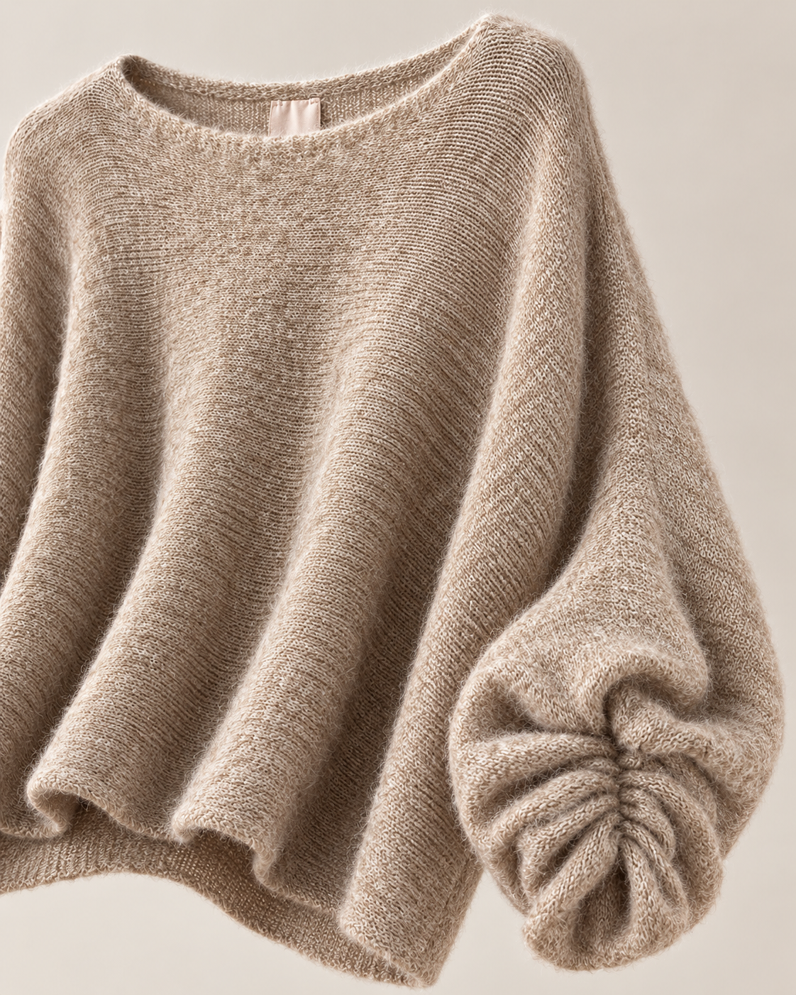 Detalle de manga fruncida del jersey oversize beige
