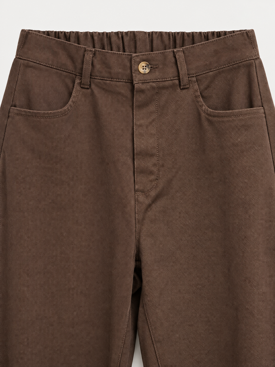 Cintura, botón y bolsillos del pantalón marron