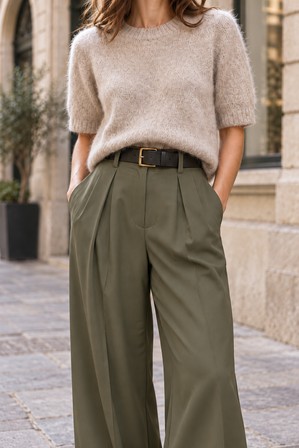 Pantalón de pinzas kaki con cinturón negro, detalle de cintura y pinzas
